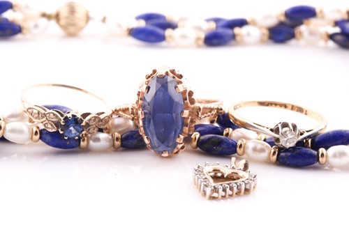 Lot 69 - A yellow metal and blue stone ring, the shank...