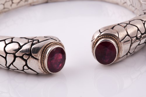 Lot 55 - A silver torque bangle, with a mixed oval-cut...