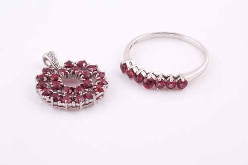 Lot 99 - A 9ct white gold and reddish orange sapphire...