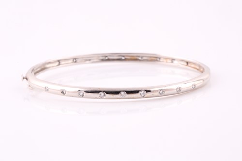 Lot 307 - A diamond set bangle; the centre with nine...
