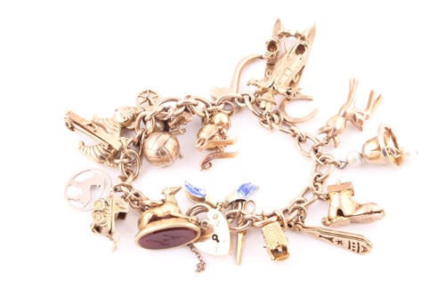 Lot 28 - A yellow metal charm bracelet, the heart...