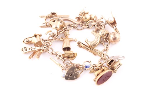 Lot 28 - A yellow metal charm bracelet, the heart...