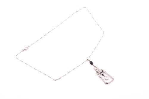 Lot 429 - An Art Deco diamond and onyx drop pendant, the...