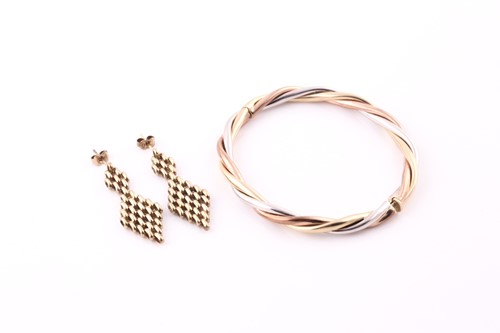 Lot 260 - A 9ct three tone gold hinged bangle, in fitted...