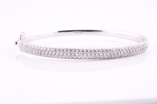 Lot 49 - A diamond set hinged bangle, pavé set with one...