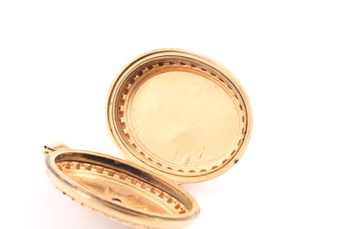 Lot 66 - A Victorian yellow metal oval-shaped locket...