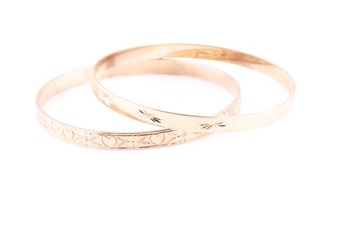 Lot 72 - A pair of yellow metal bangle bracelets, one...