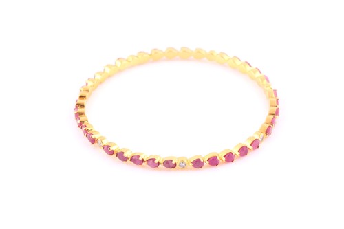 Lot 374 - A ruby and diamond bangle; composed of bands...