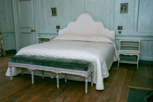 Lot 100 - An emperor sized stepped arch cream padded...