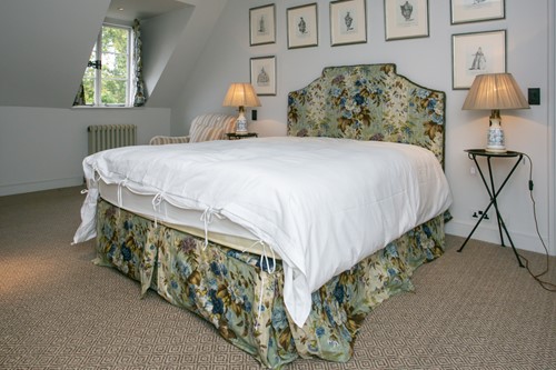Lot 23 - A floral chintz upholstered crow stepped...