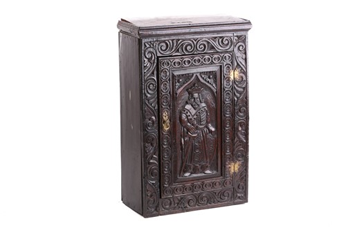 Lot 264 - An old carved oak single door wall cupboard,...