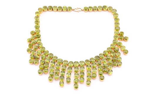 Lot 103 - A peridot fringe necklace, oval and round cuts...