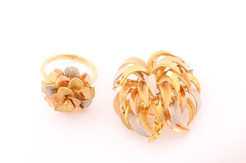 Lot 133 - A three-tone flowerhead ring on yellow metal...
