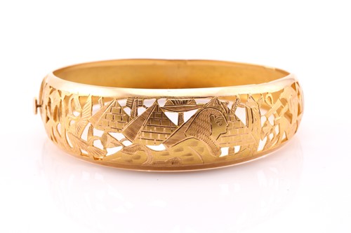Lot 162 - An Egyptian yellow metal hinged bangle, the...