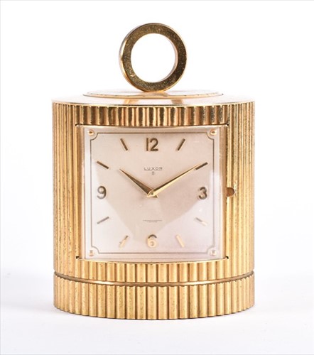 Lot 377 - A 1970s cylindrical gilt metal bedside clock...