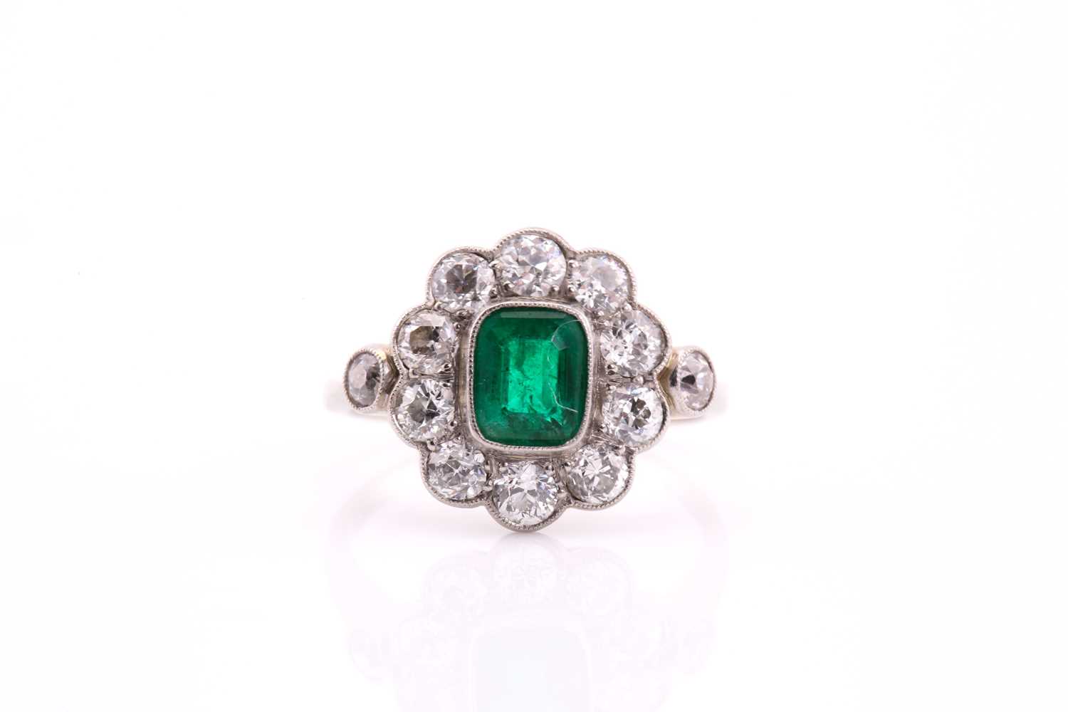 Lot 447 - An Edwardian emerald and diamond cluster ring;...