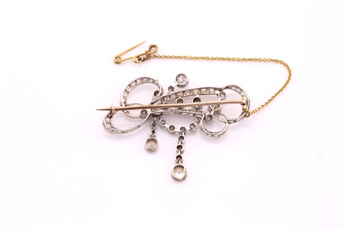 Lot 217 - An Edwardian diamond set scroll brooch,...