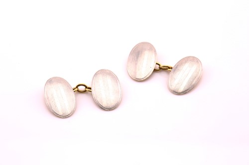 Lot 374 - A pair of oval disk cufflinks in platinum and...