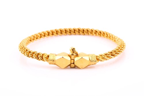 Lot 428 - A yellow metal torque style bangle, the rope...