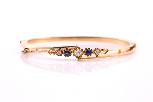 Lot 83 - A sapphire and diamond hinged bangle, the...