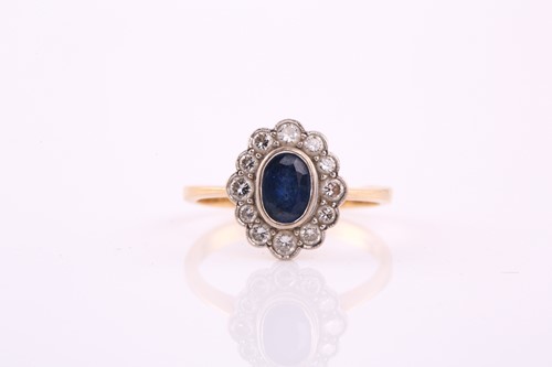 Lot 449 - A sapphire and diamond cluster ring, the oval...