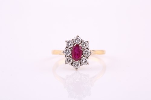 Lot 79 - A ruby and diamond cluster ring; the oval cut...