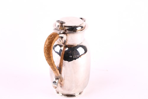 Lot 557 - A baluster shape silver hot water jug, rush...