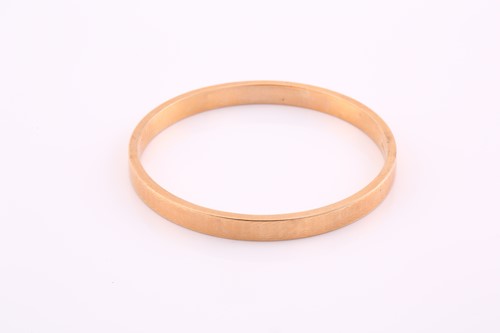 Lot 87 - A 15ct hollow gold bangle, with engine turned...