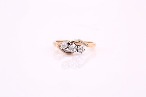 Lot 16 - A three stone diamond cross over ring; the...