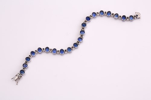 Lot 228 - A sapphire and diamond tennis bracelet,...