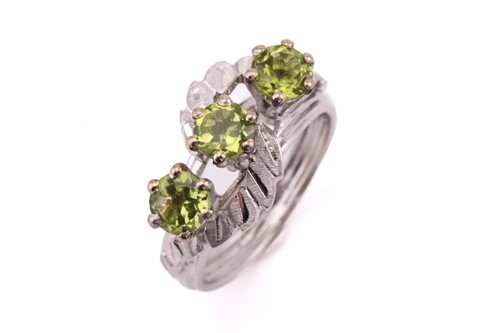 Lot 29 - A three-stone peridot ring, comprises three...