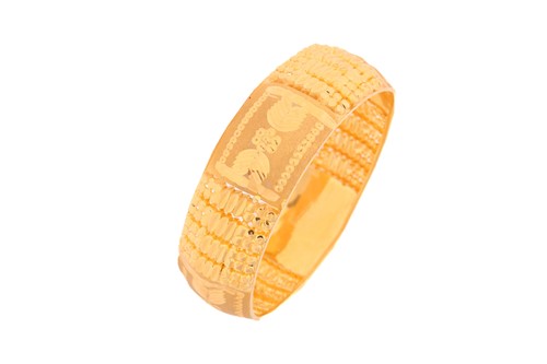 Lot 35 - A yellow metal bangle, decorated with pierced,...