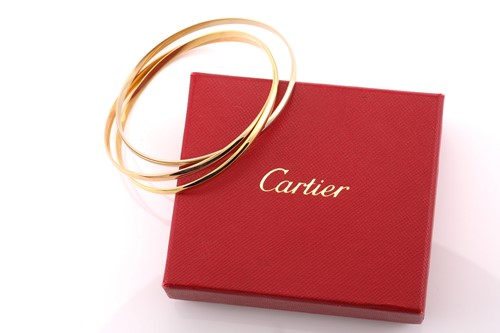 Lot 33 - A Cartier trinity bracelet, featuring three...