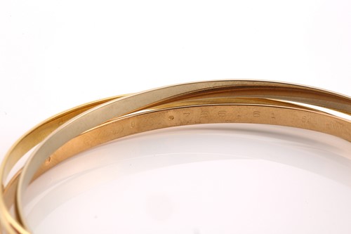 Lot 33 - A Cartier trinity bracelet, featuring three...