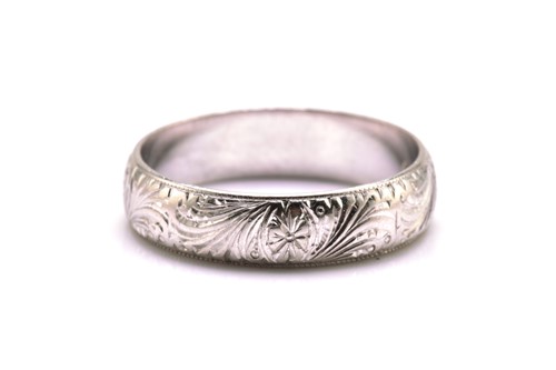 Lot 89 - A platinum engraved wedding band, with floral...