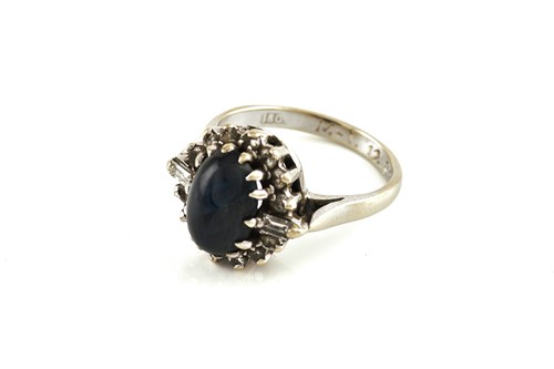 Lot 97 - A sapphire and diamond halo ring, featuring an...