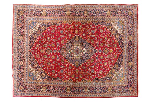 Lot 275 - A "Lacquer Red" ground room size Kashan carpet,...