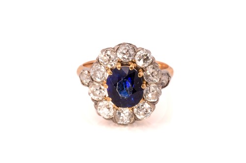 Lot 39 - A sapphire and diamond halo ring, comprises a...