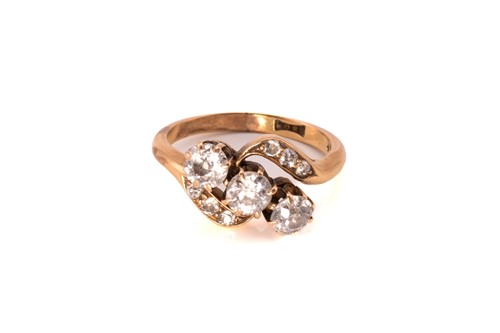 Lot 93 - A three-stone diamond bypass ring in yellow...