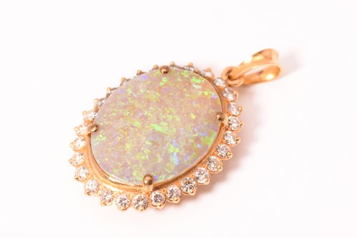 Lot 175 - An opal entourage pendant, featuring a white...
