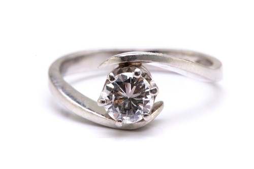 Lot 76 - A diamond solitaire bypass ring in platinum,...