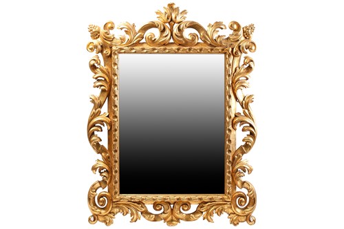 Lot 264 - A carved and gilt rococo style wall mirror,...