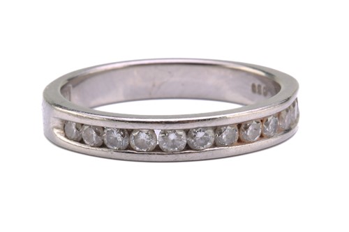 Lot 73 - A diamond half eternity ring in palladium,...