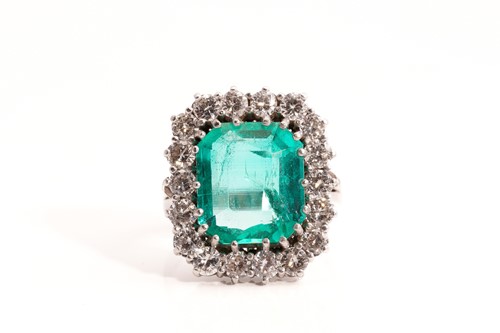 Lot 21 - An emerald and diamond entourage ring,...