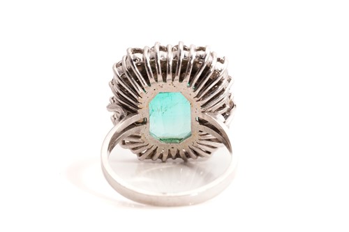 Lot 21 - An emerald and diamond entourage ring,...