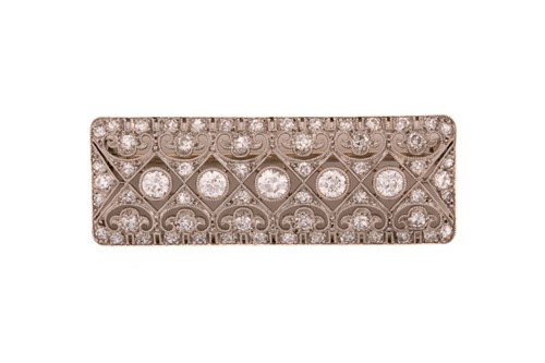 Lot 255 - An Edwardian diamond bar brooch, composed of...
