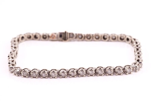 Lot 89 - A diamond line bracelet in 9ct white gold,...