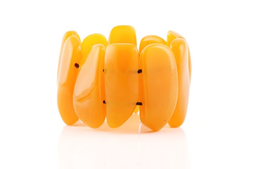 Lot 119 - An egg yolk amber panel bracelet; of ten...