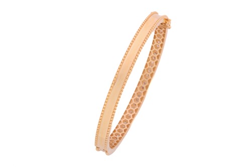 Lot 246 - A hinged bangle set with diamonds, comprising...