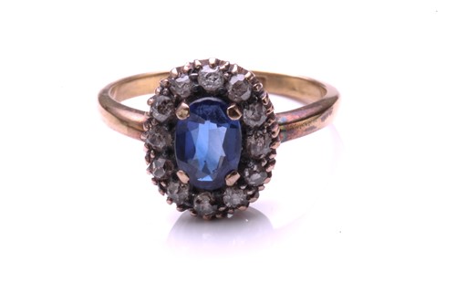 Lot 183 - A sapphire and diamond cluster ring; the oval...